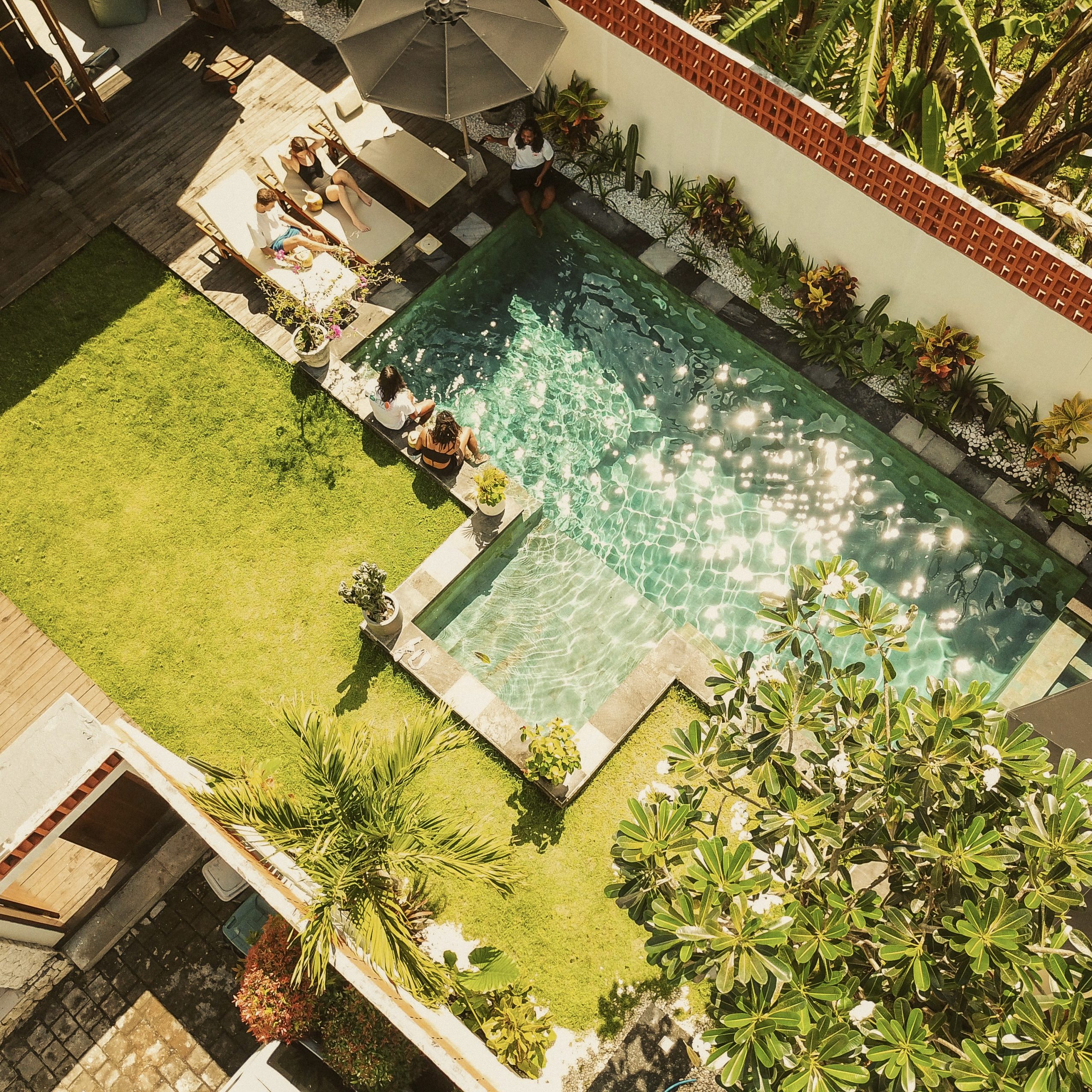 Aerial view of the pool and garden area at a surf stay package in Bali.