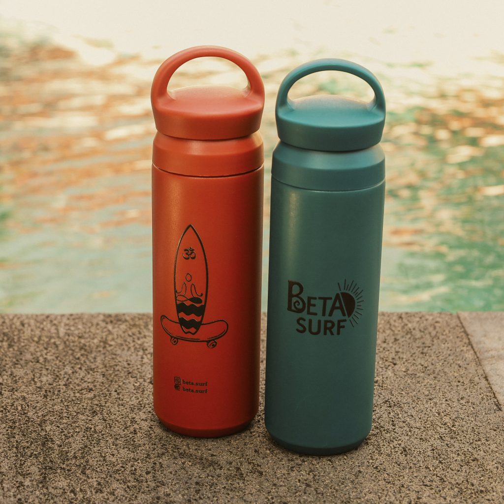 BETA Surf Camp branded water bottles by the poolside