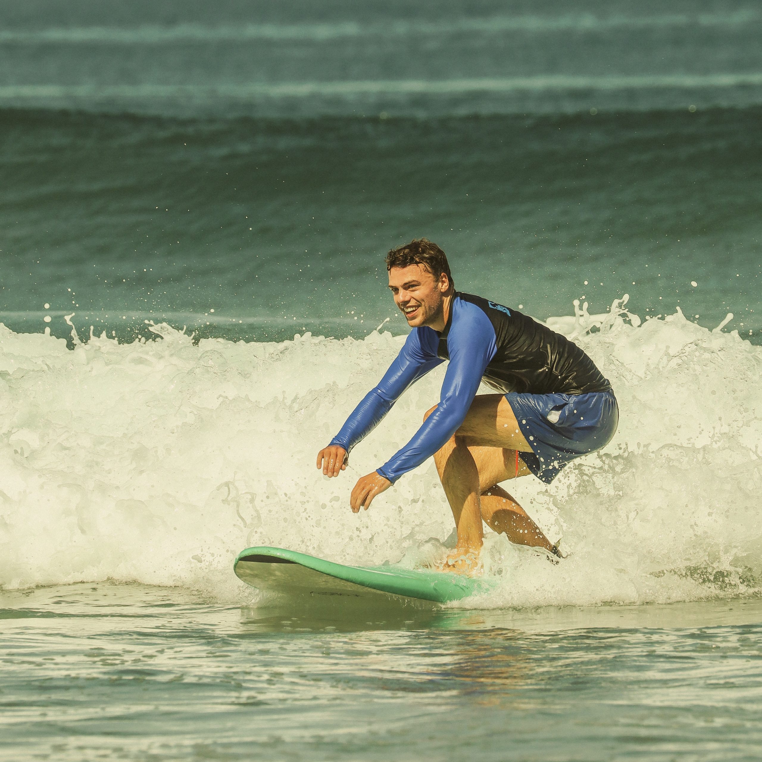 Beginner catching a wave during surf lesson in Bali with BETA Surf Camp