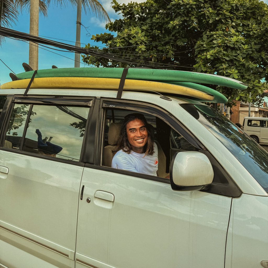 Surf student arriving at BETA Surf Camp Bali for surf lessons with boards on the roof